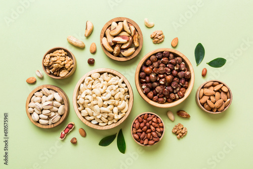 mixed nuts in wooden bowl. Mix of various nuts on colored background. pistachios, cashews, walnuts, hazelnuts, peanuts and brazil nuts