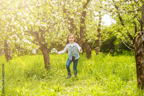 Beautiful little girl near the blossom tree © Angelov