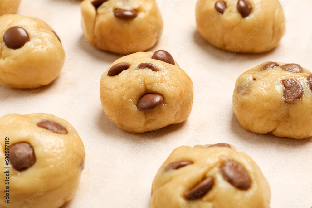 Unbaked chocolate chip cookies on white table, closeup