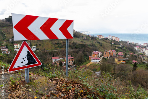 Mountain road road signs, dangerous turn and Falling rocks