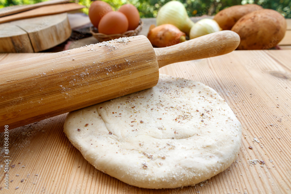 Rolling pin and dough on garden table covered with flour Rolling pin and dough on garden table covered with flour