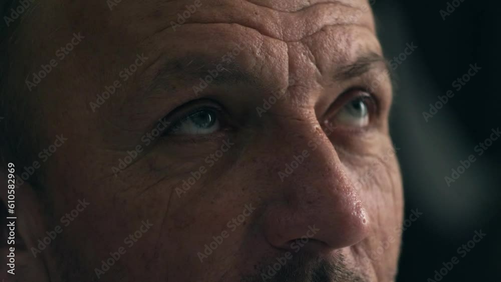 Close-up portrait of serious mature middle age man with wrinkles opening his beautiful blue eyes and looking up. Cinematic 4K footage Close-up portrait of serious mature middle age man with wrinkles opening his beautiful blue eyes and looking up. Cinematic 4K footage