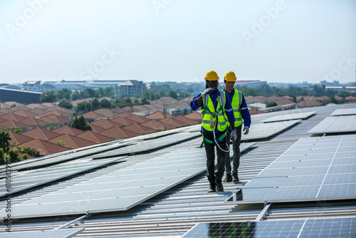 professional technician or engineer installing solar panels, Alternative energy for installed solar panels in use on roof of home © FotoArtist