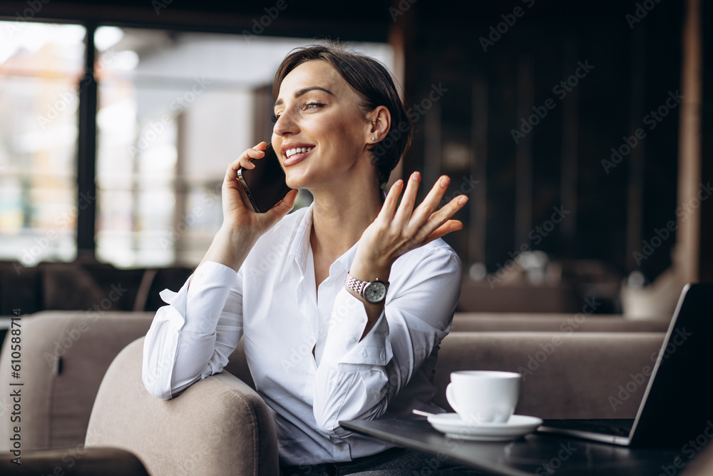 Business woman in a cafe working on laptop and using phone Business woman in a cafe working on laptop and using phone