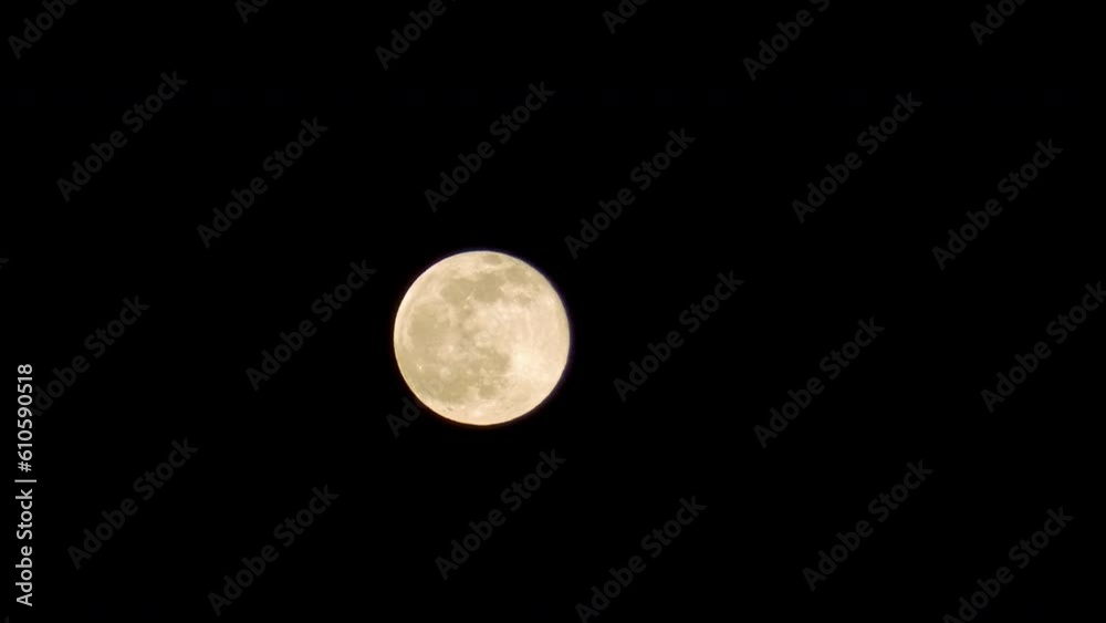 Yellow full moon at dark night background. Earth's only natural satellite, fifth largest satellite in the Solar System. Timelapse footage Yellow full moon at dark night background. Earth's only natural satellite, fifth largest satellite in the Solar System. Timelapse footage