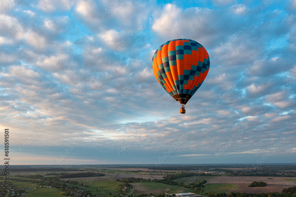 Hot air balloon in blue sky at sunrise
