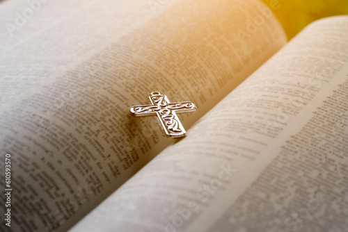 Fototapeta Closeup image of metal cross which places on opending bible book, soft focus, concept for religious lifestyle of christian people around the world