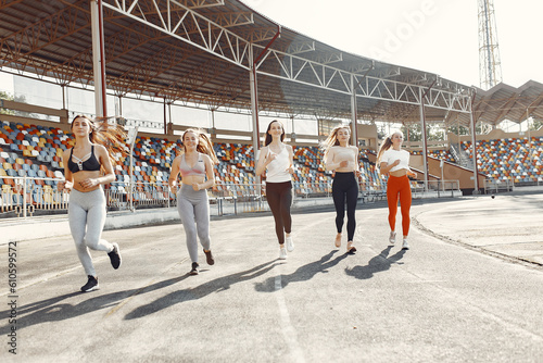 Five sports girls in a uniform training at the stadium