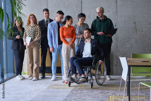 Diverse group of business people, including a businessman in a wheelchair in a modern office