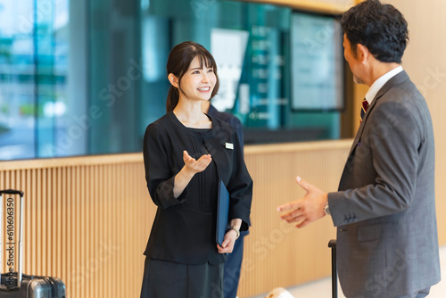 Foto フロントで旅行客を接客する案内係の女性
