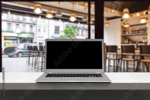 Modern computerlaptop with blank screen on counter bar(retail store shop)and window view backgrounds