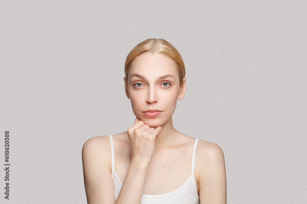 Beauty young blonde woman with clean skin looking at camera. Facial treatment, skincare and cosmetology concept Beauty young blonde woman with clean skin looking at camera. Facial treatment, skincare and cosmetology concept
