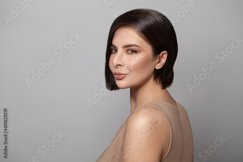 Beautiful woman portrait. Female model with clean shiny fresh skin and short bob hairstyle looking at camera