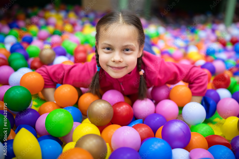 Little smiling girl having fun with balls in amusement center for kids Little smiling girl having fun with balls in amusement center for kids