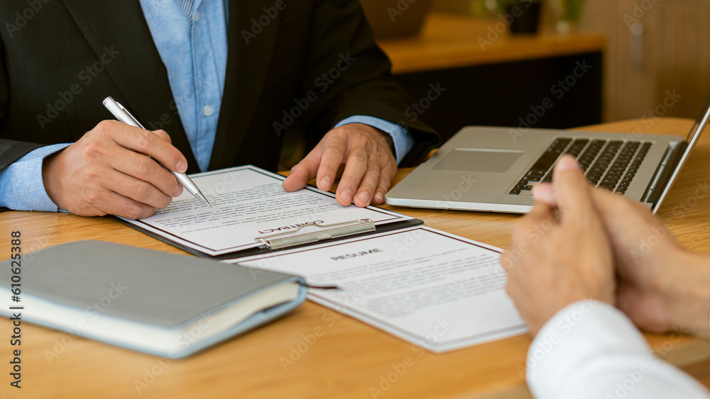 Executive reading resume during job interview and businessman filling in application form Concept of successful hiring and recruitment of human resources. Executive reading resume during job interview and businessman filling in application form Concept of successful hiring and recruitment of human resources.