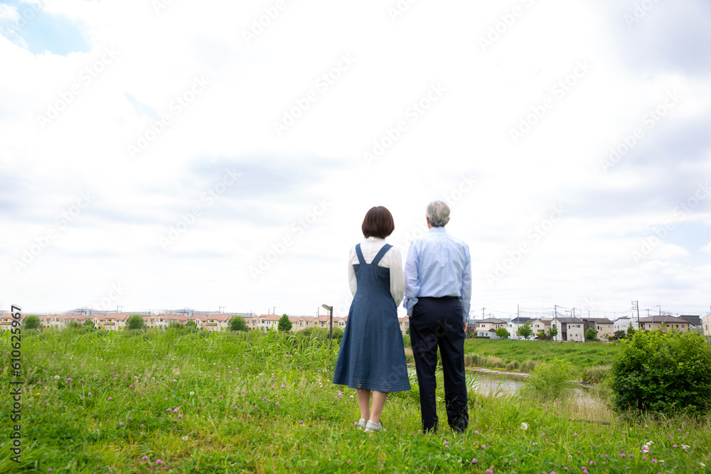 日本人ミドル夫婦の後ろ姿、公園で手を繋ぎ全身、