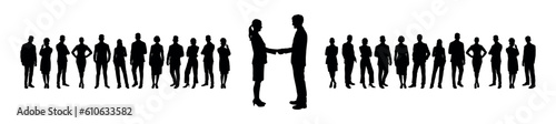 Businessman and businesswoman shaking hands standing in front of large group of business people silhouettes.