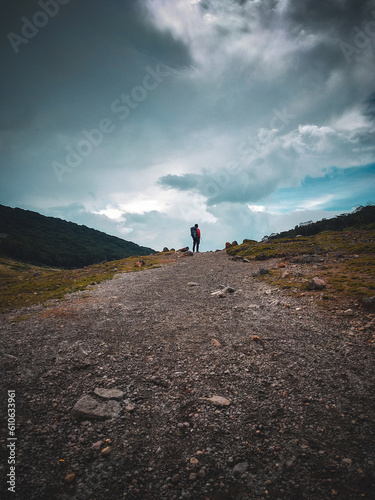 Dramatic view of a man standing between 2 hills when hiking over Mount Gede Pangrango photo