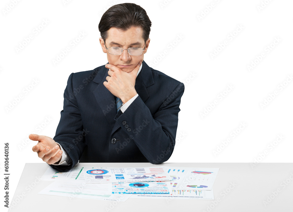 Young businessman sitting at desk and looking in chart Young businessman sitting at desk and looking in chart