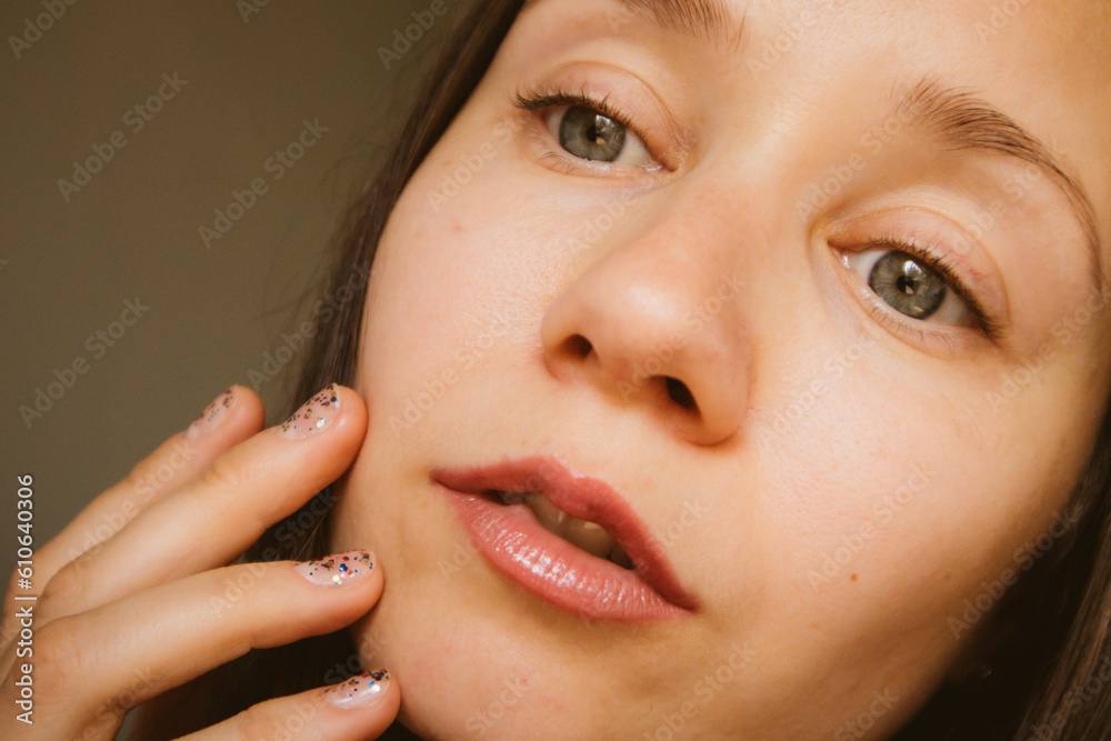 Beautiful white European young woman portrait close-up. A thoughtful, enigmatic girl with gray eyes looking somewhere. Beautiful natural makeup with emphasis on sensual lips. Thoughtful female beauty. Beautiful white European young woman portrait close-up. A thoughtful, enigmatic girl with gray eyes looking somewhere. Beautiful natural makeup with emphasis on sensual lips. Thoughtful female beauty.