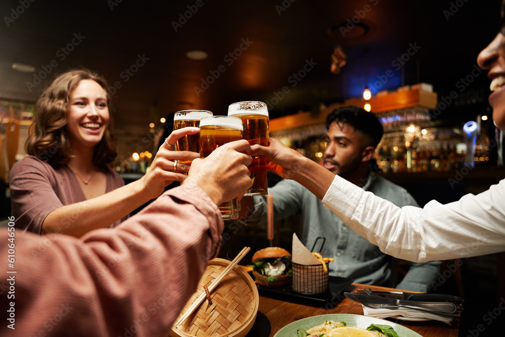 Happy young multiracial group of friends in casual clothing doing toast with beers at bar