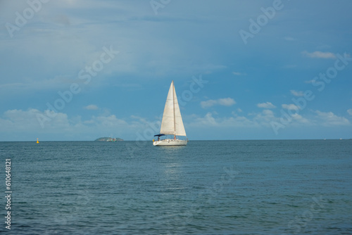 White yacht boat sail on turquoise water blue sky with cloud