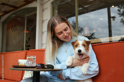 Young woman enjoying the morning cup of coffee with her wire haired jack russell terrier pup. Close up, copy space, background.