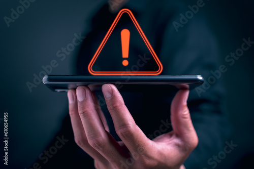 Businessman or it staff , programmer, developer using smart phone with triangle caution warning sign for notification error and maintenance concept. remote work by phone connection application.