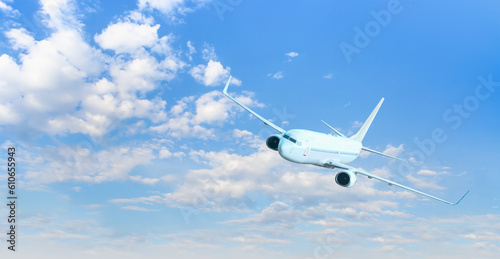 White passenger airplane flying in the sky amazing clouds in the background - Travel by air transport