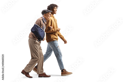 African american guy walking with a senior man with an injured arm in a sling