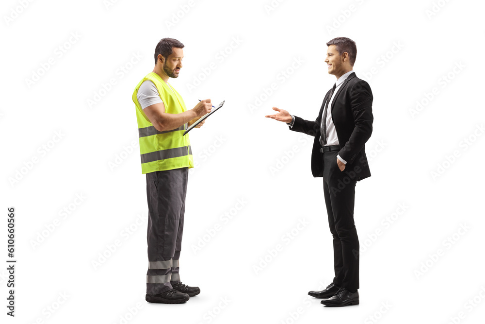 Road assistance worker in a reflective vest writing a document and talking to a businessman Road assistance worker in a reflective vest writing a document and talking to a businessman