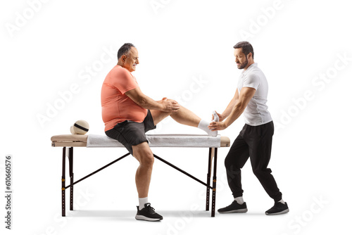 Physical therapist treating foot of a mature man