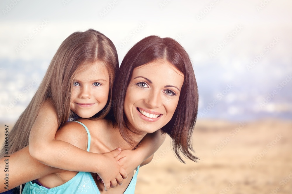 Happy young Mother and cute child on beach