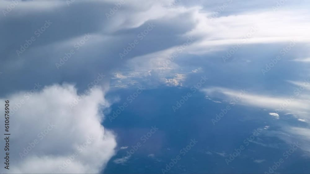 Point of view from the airplane,ฺ Blue sky and white clouds from airplane look through window above cloud background. The plane passes through the rain clouds. Point of view from the airplane,ฺ Blue sky and white clouds from airplane look through window above cloud background. The plane passes through the rain clouds.