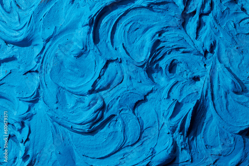 Decorative blue putty background. Wall texture with filler paste applied with spatula, chaotic dashes and strokes over plaster. Creative design, stone pattern, cement.