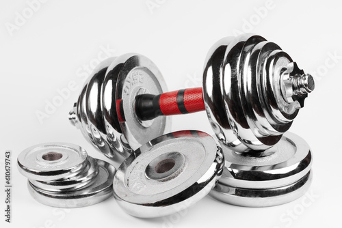 Metal demountable dumbbell with black plates and red handle isolated on white background photo