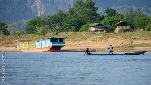 Asians on a pirogue on the mekong river in Luang Prabang, Laos photo