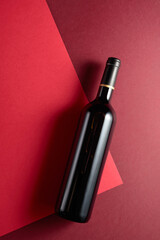 Bottle of red wine on a red background.