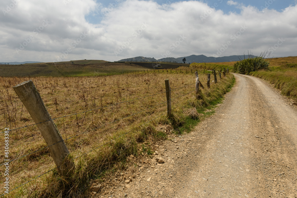 Obraz premium Harvested maize field by the road with a bar wire fence