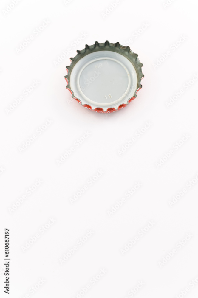 immagine con primo piano di tappo classico in metallo a corona su superficie bianca, lato posteriore immagine con primo piano di tappo classico in metallo a corona su superficie bianca, lato posteriore