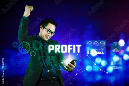 Happy businessman with profit looking at his mobile phone