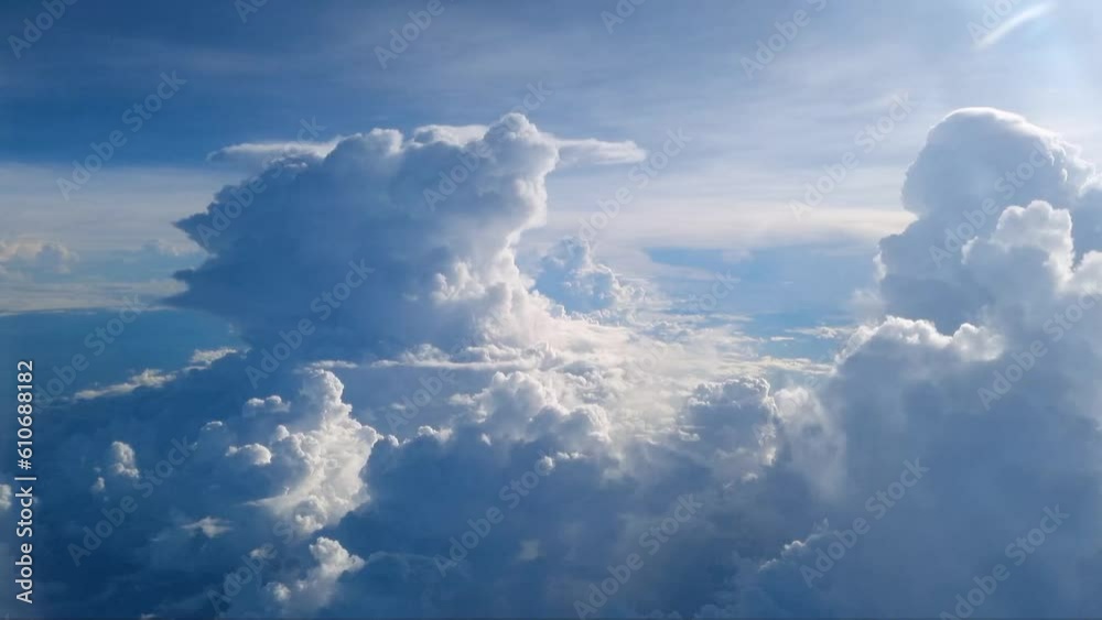 Point of view from the airplane, Blue sky and white clouds from airplane look through window above cloud background. Traveling and tourism