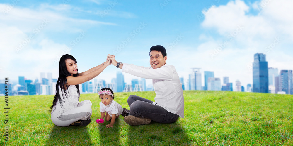 Happy family of father mother and daughter playing at meadow Happy family of father mother and daughter playing at meadow