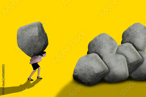 Businesswoman holding up a big rock
