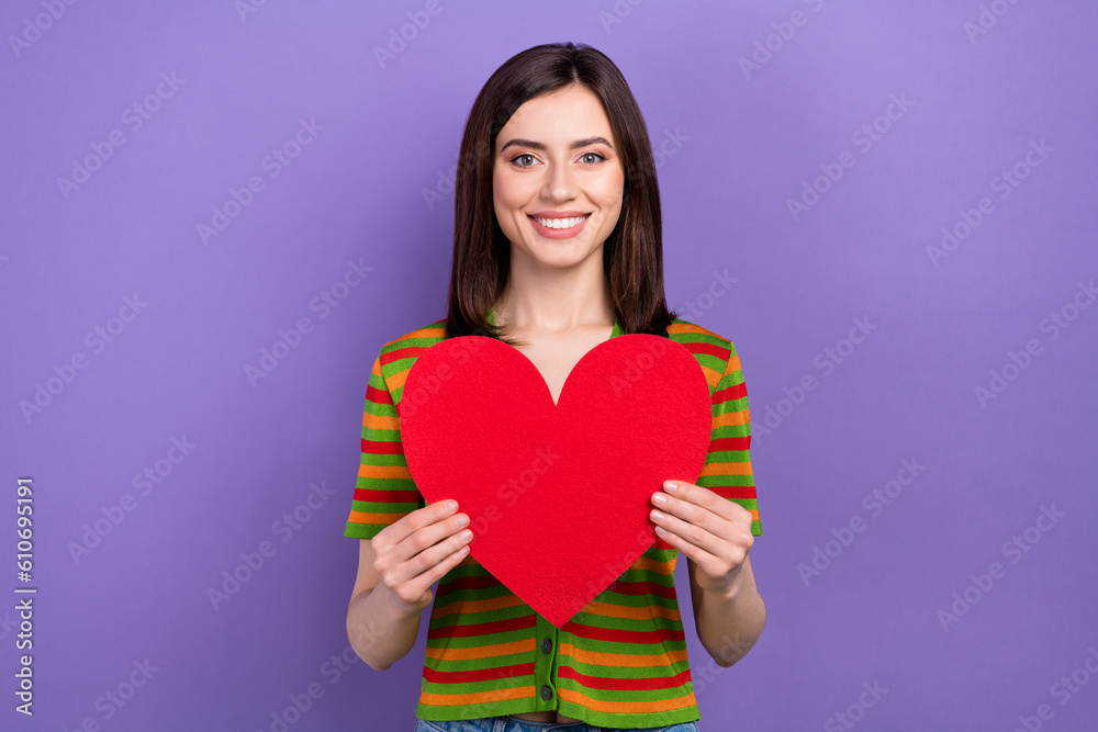 Portrait of cute nice girl stylish hairdo dressed striped cardigan hands hold big red heart postcard isolated on violet background Portrait of cute nice girl stylish hairdo dressed striped cardigan hands hold big red heart postcard isolated on violet background