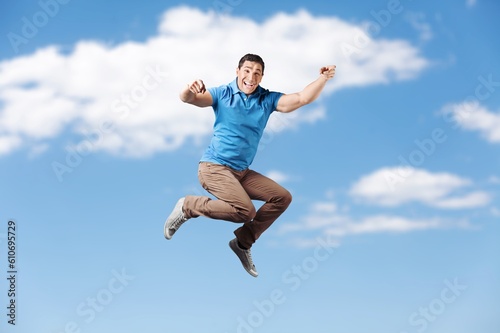 Young fun person jump on sky background