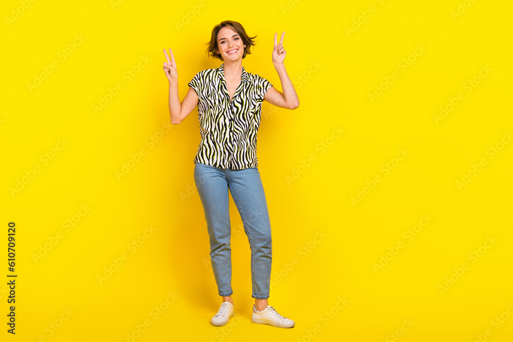 Full size photo of funny nice lady excited show v sign symbols hands wear print blouse jeans shoes isolated yellow color background