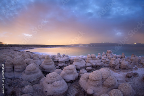 Photo of a salt mushrooms in the dead sea with a sunrise in the the background and clouds in the sky © Felix Tchvertkin