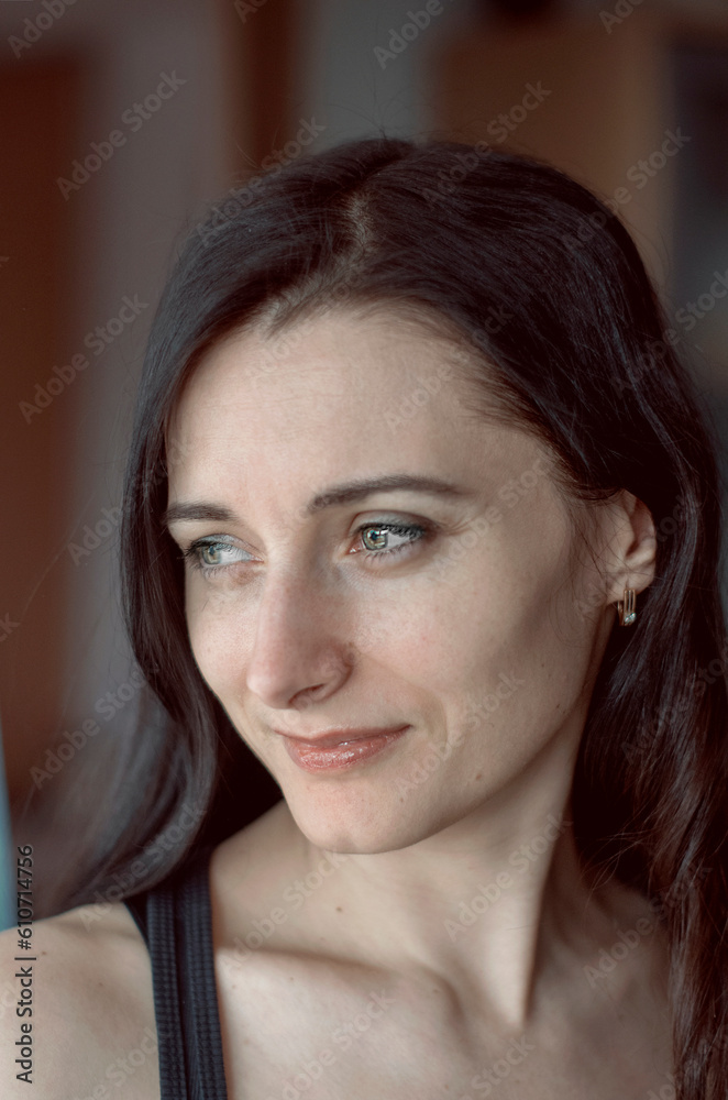 Lifestyle portrait of mid adult woman looking at camera at home. Nice female face smiling. Green Eyes. Brown-haired middle aged lady. Age from 30 to 40 years Lifestyle portrait of mid adult woman looking at camera at home. Nice female face smiling. Green Eyes. Brown-haired middle aged lady. Age from 30 to 40 years