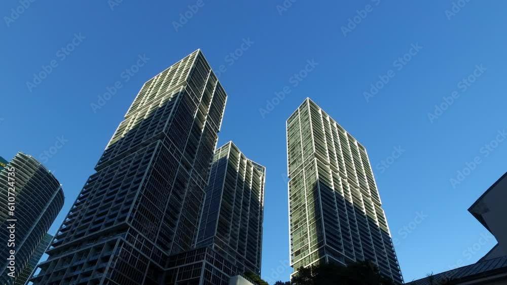 Panning Shot Of Tall Modern Buildings In City Against Clear Blue Sky On Sunny Day - Miami, Florida Panning Shot Of Tall Modern Buildings In City Against Clear Blue Sky On Sunny Day - Miami, Florida